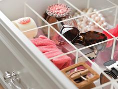 an open drawer with sunglasses and other items in it