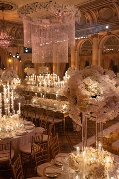 the tables are set with white flowers and candles