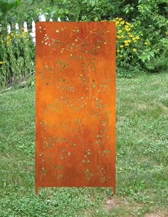 an orange metal sculpture sitting in the grass