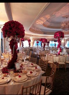 the tables are set with flowers and place settings for an elegant wedding reception in a ballroom