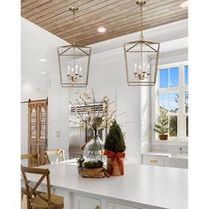 a kitchen with white counter tops and wooden ceiling lights hanging from it's ceiling