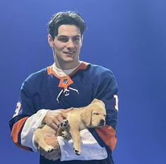 a man holding two puppies in his arms