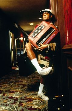 a man is sitting on the floor with an accordion in his hand and wearing white socks