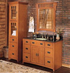 a bathroom with a brick wall and wooden cabinets