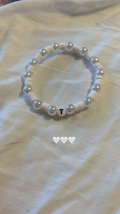 a white beaded bracelet with two hearts on it