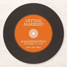 an orange and black wedding save the date label on a white coaster that reads, getting married