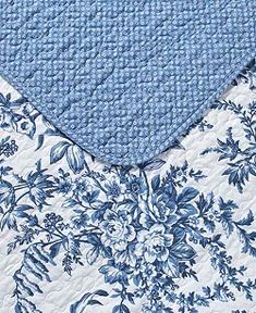 a blue and white floral quilted bed spread