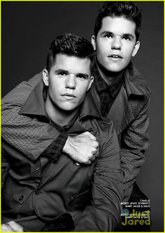 two young men posing for the camera in black and white, one with his arm around the other's shoulder