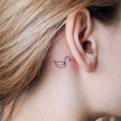 a woman's ear with a small tattoo on it