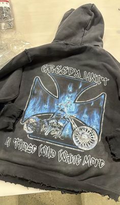 the back of a black jacket with an image of a motorcycle on it