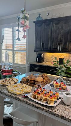 a kitchen counter topped with lots of pastries and desserts on top of it