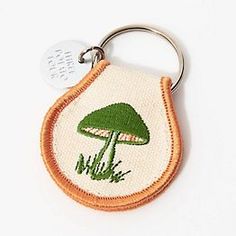 an embroidered keychain with a green mushroom on it