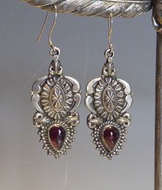 A fine vintage pair silver boho design long drop earrings. decorative silver raised pendant earrings set with a cabachon pear shaped cut real garnet. mounted with silver  shepherd hook fittings. drop length 6cm x 2.2cm wide.stamped 925 on backs. Ornate Sterling Silver Teardrop Earrings As Gift, Ornate Sterling Silver Teardrop Earrings For Gift, Metal Teardrop Jewelry With Intricate Design, Vintage Drop Earrings With Matching Set, Vintage Drop Jewelry Set With Matching Earrings, Ornate Teardrop Jewelry With Intricate Design, Bohemian Silver Drop Jewelry, Antique Oxidized Dangle Jewelry, Vintage Silver Teardrop Jewelry