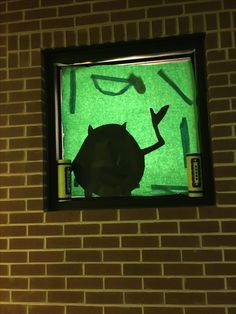 a cat sitting in front of a window with green light shining on it's side