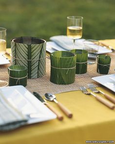 the table is set with glasses, plates and utensils