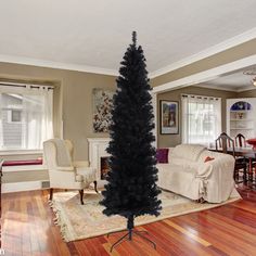 a living room filled with furniture and a black christmas tree on top of a wooden floor