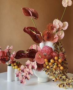 a white vase filled with lots of different types of flowers on top of a table