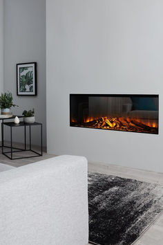 a living room with a white couch and a fire place in the middle of it