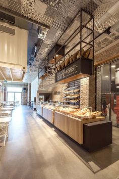 the inside of a restaurant with lots of food on tables and chairs in front of it