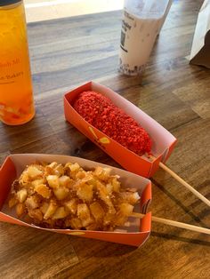 two boxes filled with food sitting on top of a wooden table next to a drink