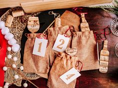 three bags with numbers on them sitting next to some other decorations and wine corks