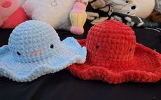 several stuffed animals sitting on top of a black table covered in crocheted material