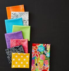 several different colored napkins on a black surface with polka dots and flowers in them