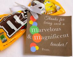 two chocolate candies wrapped in brown paper and tied with a white ribbon, next to a thank card