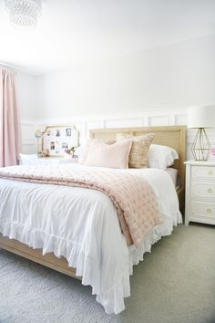 a bedroom with a bed, dresser and pink drapes on the window sill