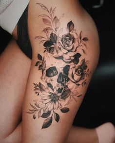 a woman's thigh with flowers and skulls on it