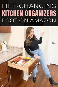 a woman sitting on top of a kitchen counter next to an open drawer filled with food