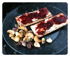 two pieces of toast with peanut butter and jelly on them sitting on a black plate