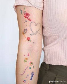 a woman's arm with tattoos on it, including hearts and keyes in the shape of a heart