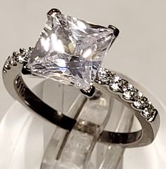 a white gold ring with a princess cut diamond