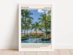 a framed photograph of a tropical resort with palm trees and a pool in the foreground