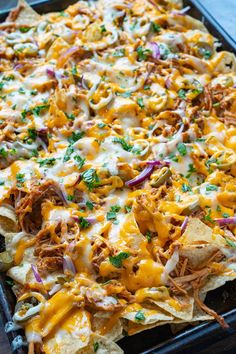 a tray filled with nachos covered in cheese and toppings on top of it