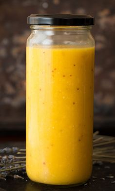 a jar filled with yellow liquid sitting on top of a table