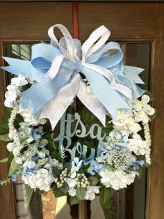 a blue and white wreath with the words happy new year on it is hanging in front of a door