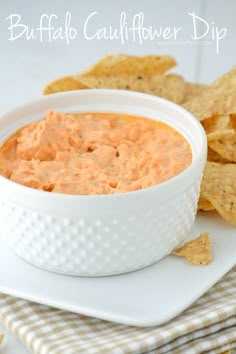 a bowl of buffalo cauliflower dip with tortilla chips on the side