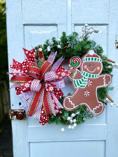 a christmas wreath with a gingerbread man and candy canes on the front door