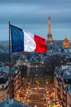 the flag of france is flying in front of the eiffel tower