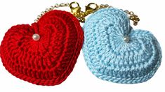 two crocheted heart shaped keychains with chain attached to them, one red and the other blue