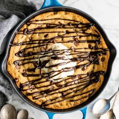 a chocolate chip cookie in a cast iron skillet with ice cream drizzled on top