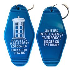 two blue key chains with the words police box, tardis entry and lockafter leaving on them