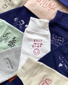 many different colored shirts with embroidered words on the front and back, including one saying best mum ever