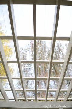 the ceiling is covered with glass panels and wood slats as it sits in front of a window