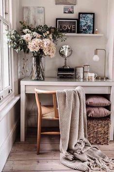 a white desk with flowers and pictures on the wall