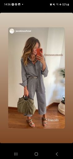 a woman taking a selfie with her cell phone while wearing overalls and sandals