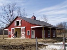 a red barn with white doors and windows