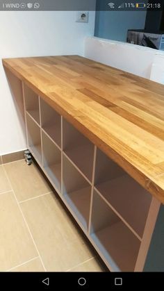 a wooden counter top sitting on top of a tiled floor